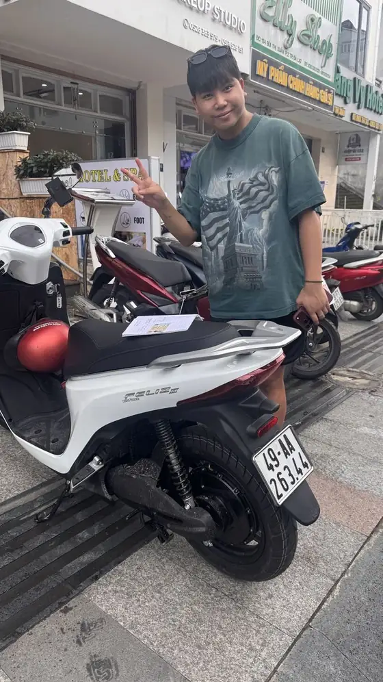 Smiling guest with a white electric scooter rented from Van Phu in Da Lat