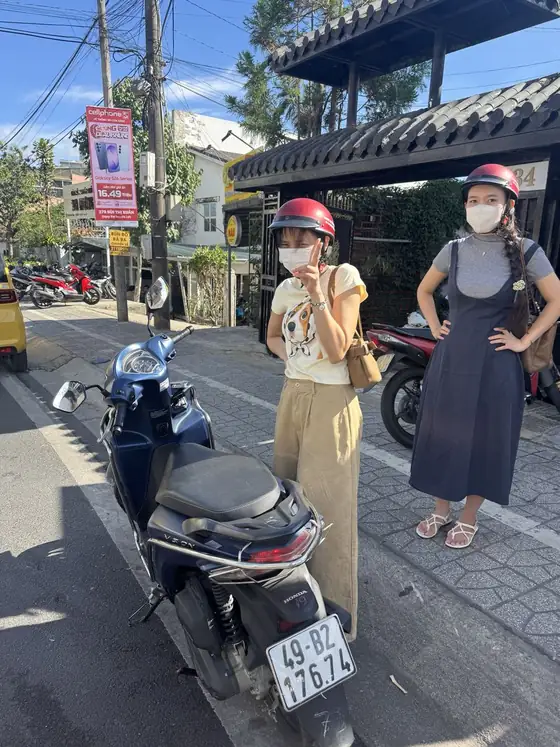 ダラット中心部の通りで青いHonda Visionと旅行者2人